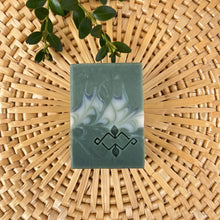 Load image into Gallery viewer, Square soap bars in dark and light sage green, with grey and white swirls and a stamped Woods and Mosses company logo on the surface.