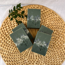 Load image into Gallery viewer, Square soap bars in dark and light sage green, with grey and white swirls and a stamped Woods and Mosses company logo on the surface.