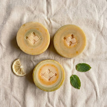 Load image into Gallery viewer, Three round vegan soaps with green white and yellow swirls in clean minimalist style
