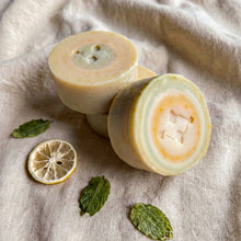 Load image into Gallery viewer, Round lemon and peppermint artisan soap bars with pale green and yellow swirls and embossed logo