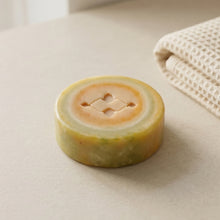 Load image into Gallery viewer, Lemon peppermint vegan artisan soap with pale green and yellow swirl pattern and Woods and Mosses stamped logo