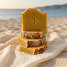 Load image into Gallery viewer, Stack of handmade mango soap bars with one upright bar showing the front design and logo stamp.