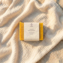 Load image into Gallery viewer, Mango artisan soap bar partially wrapped in a Woods &amp; Mosses paper sleeve.