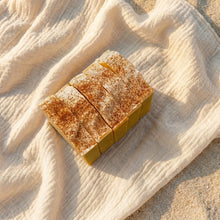 Load image into Gallery viewer, Five mango soap bars arranged side by side, showing textured white tops and golden sides.