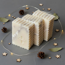 Load image into Gallery viewer, artisan shea butter marble soap bar displayed in a set of three with ribbed edges on a grey background with wooden stars and pinecones