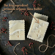 Load image into Gallery viewer, Two bars of soap with marble designson a dark surface with text about premium organic Shea Butter.