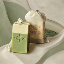 Load image into Gallery viewer, Matcha latte soap on a rope with cream and green layers beside a wrapped artisan bar soap by Woods and Mosses.