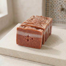 Load image into Gallery viewer, Row of Moroccan clay soap bars with stamped front, white stripe, speckled face, and textured tops