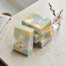 Load image into Gallery viewer, Four pastel artisan soap bars stacked together, showing marbled swirl patterns and sculpted edges by Woods and Mosses