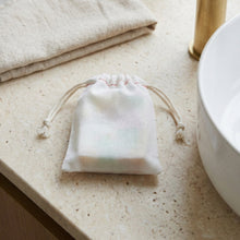 Load image into Gallery viewer, Pastel artisan soap bar tucked inside a small cotton drawstring bag.
