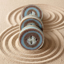 Load image into Gallery viewer, Three River Stone round bar soaps stacked upright, highlighting the layered pebble-like design.