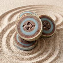 Load image into Gallery viewer, Four River Stone round soap bars stacked together, showing the handmade layered stone-like pattern.