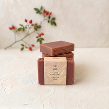 Load image into Gallery viewer, Wrapped rosehip artisan soap bar displayed in front of three stacked bars.