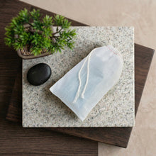 Load image into Gallery viewer, White cotton soap saver bag holding a sandalwood natural soap bar