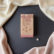 Charger l'image dans la galerie, Top view of one rectangular pink silk soap bar with floral swirl pattern, stamped front, and rose base