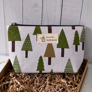 Handmade cotton zipper pouch with green and brown geometric tree print, labeled Natural Style Handmade, placed on kraft paper shred as part of an eco-friendly gift set.