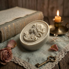 Load image into Gallery viewer, Angled ivory oval cameo soap showing thick handmade bar and raised portrait design