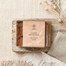 Load image into Gallery viewer, Wrapped handmade artisan soap bar showing brown wood-grain edges, with 'Woods &amp; Mosses' branding.
