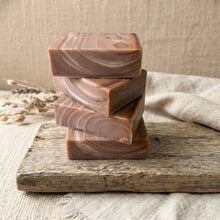 Load image into Gallery viewer, Stack of four handmade artisan soap bars with flowing brown wood-grain swirl pattern.