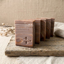 Load image into Gallery viewer, Stack of four handmade artisan soap bars with flowing brown wood-grain swirl pattern.