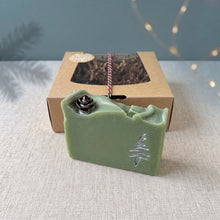 Load image into Gallery viewer, Close view of the pale green Holiday Pine soap with a small pinecone and hand-painted silver tree beside its kraft gift box.