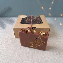 Load image into Gallery viewer, Close view of the brown Christmas Eve soap with hand-painted gold stars and dried orange pieces beside its kraft gift box.