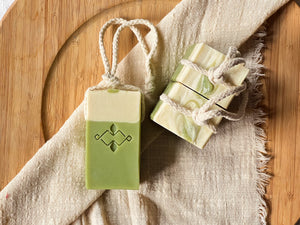 Top view of matcha soap on a rope, highlighting swirl top and bundled cotton cords. Eco-conscious, handmade soap with creamy matcha latte scent.