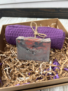 Marbled grey and red artisan soap bar in men’s spa gift box with purple cloth.