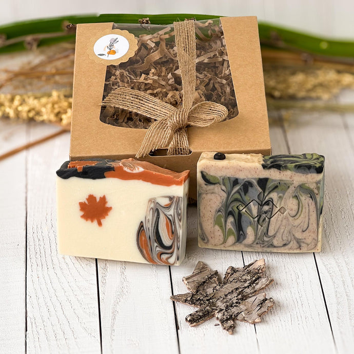 Handcrafted soap bars with autumn-inspired swirls and a maple leaf motif, styled with rustic packaging and natural decor.
